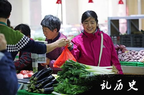 市民在农贸市场内选购蔬菜。
