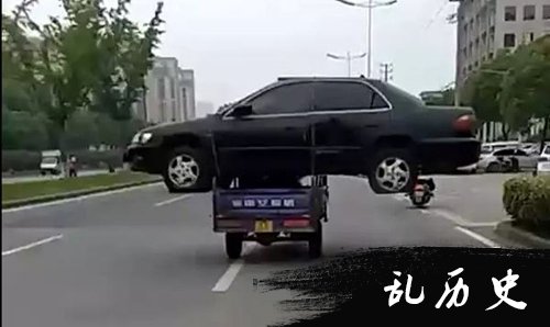三轮车扛报废轿车路上飞奔